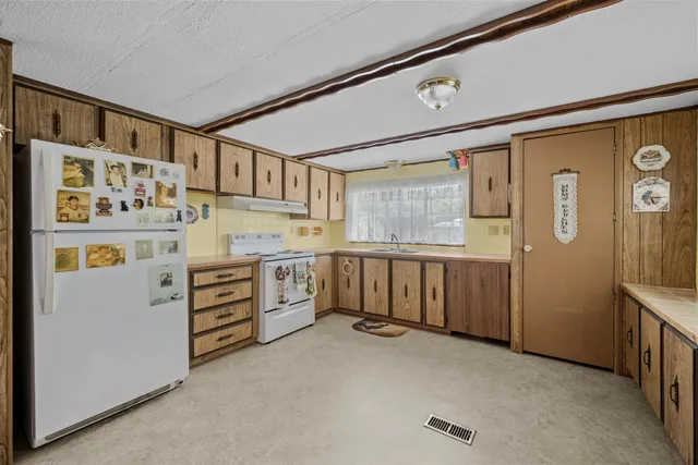 a kitchen with stainless steel appliances a refrigerator sink and cabinets