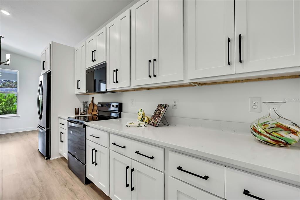 6589 Freeport Drive Spring Hill, FL 34608 - Photo 20 of 63 a kitchen with stainless steel appliances granite countertop a sink a stove and a white cabinets