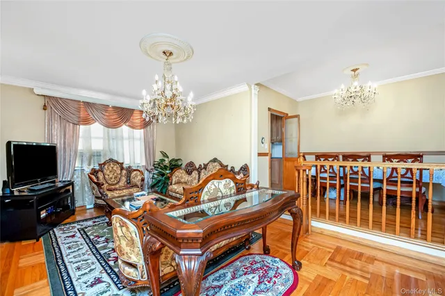a living room with furniture a chandelier and a flat screen tv