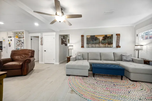 a living room with furniture a ceiling fan and a rug