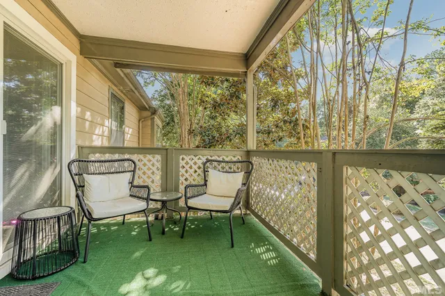 a balcony with couple of chairs and a swing