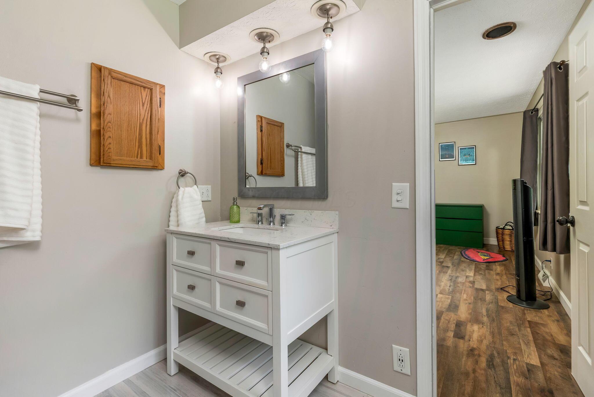 14823 Cleveland Road Southwest Pataskala, OH 43062 - Photo 21 of 57 Bathroom vanity featuring a white cabinet with drawers, a quartz-finish countertop, and an undermount sink