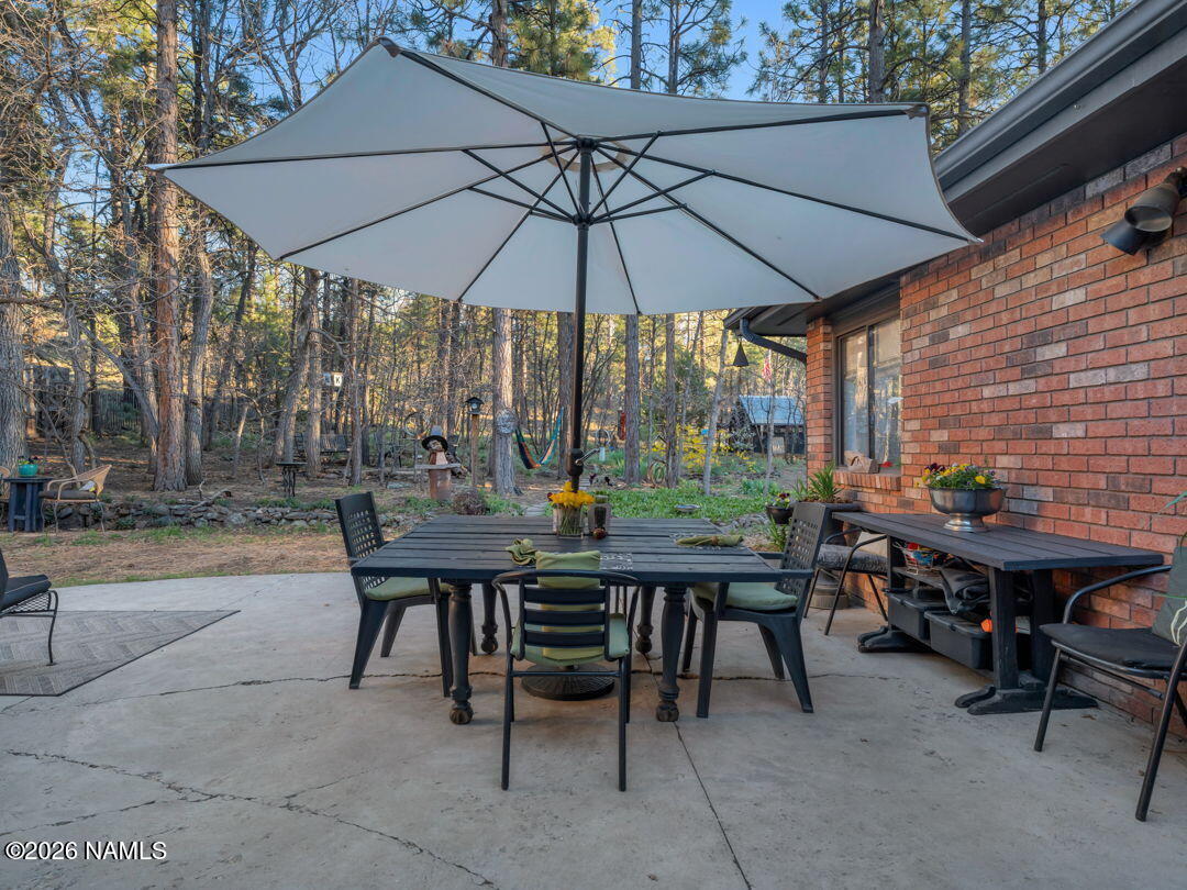 1005 Park Way Williams, AZ 86046 - Photo 30 of 45 a patio with a table and chairs under an umbrella