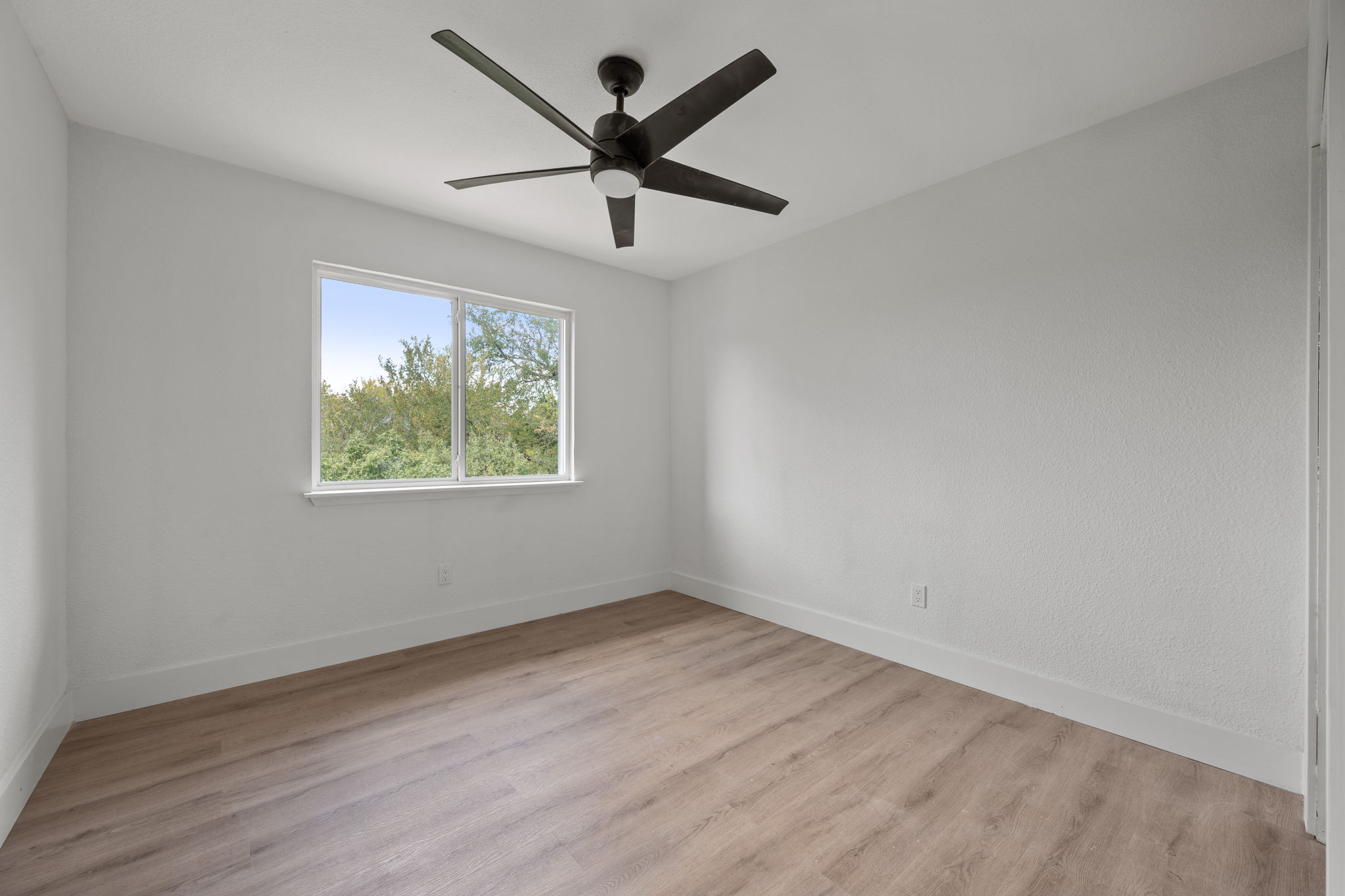 11604 Loweswater Lane Austin, TX 78754 - Photo 26 of 34 an empty room with wooden floor ceiling fan and window