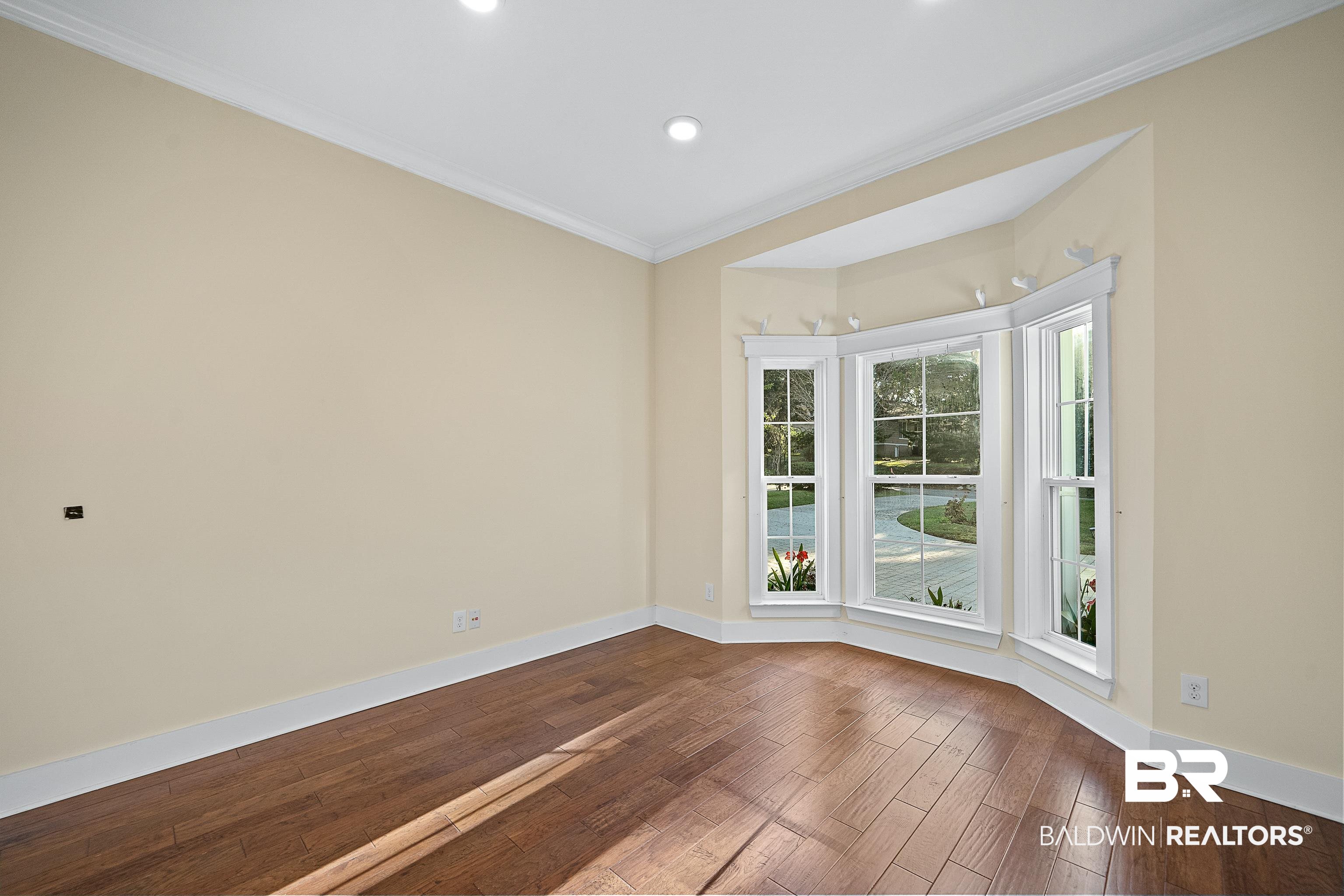356 Liberty Street Fairhope, AL 36532 - Photo 18 of 39 Empty room with crown molding, dark wood-style floors, and recessed lighting