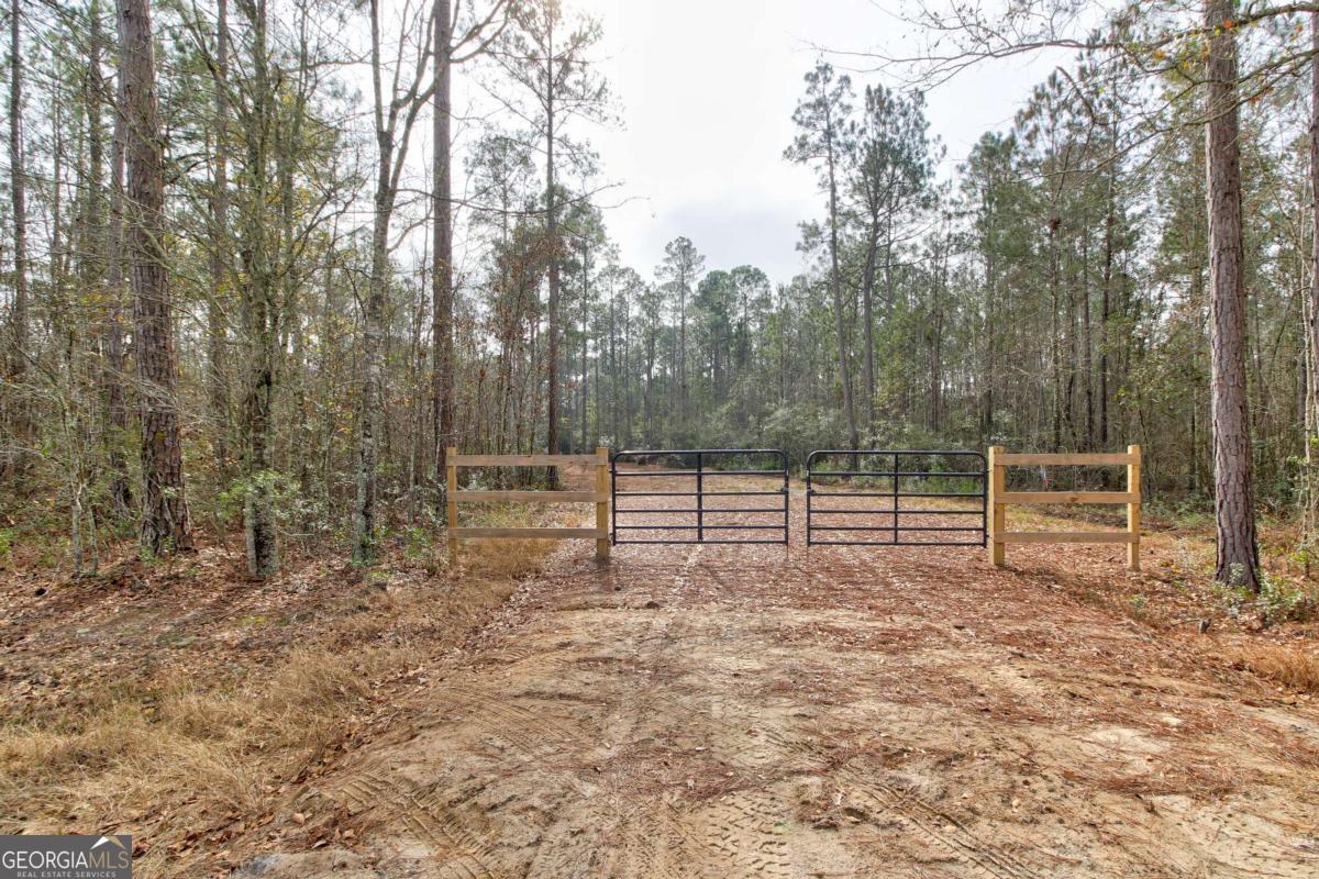 a view of a yard with wooden fence