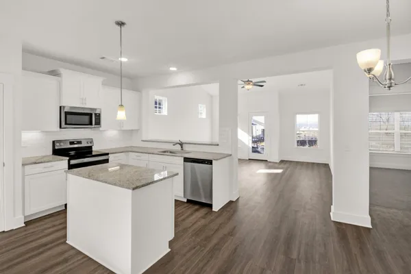 a kitchen with a sink stove and wooden floor