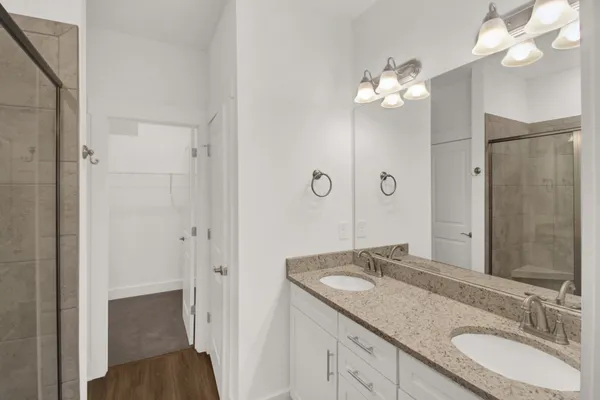 a bathroom with a granite countertop sink a large mirror and a shower