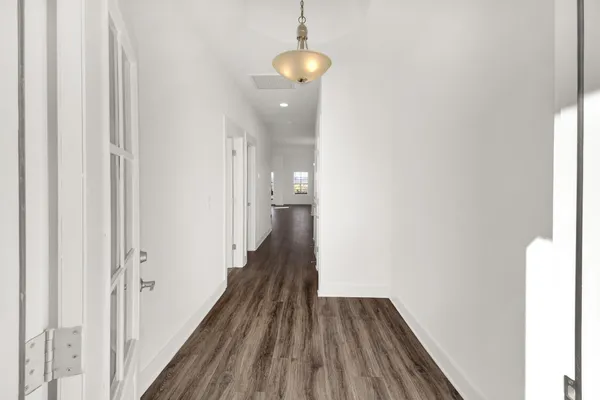 a view of a hallway with wooden floor and staircase