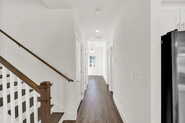 a view of a hallway with wooden floor and staircase