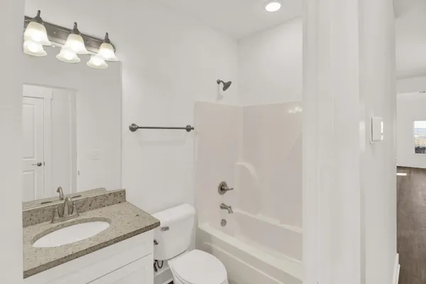 a bathroom with a granite countertop sink toilet tub and shower