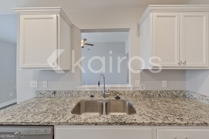 228 Western Red Cedar Drive Springfield, GA 31329 - Photo 10 of 27 a kitchen with kitchen island granite countertop white cabinets and a sink