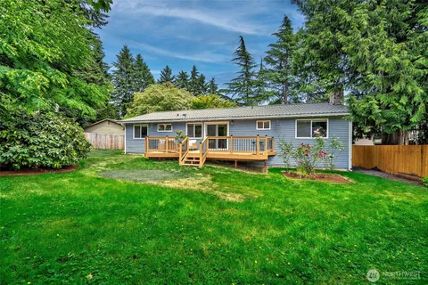 a view of a house with a yard deck and a small yard