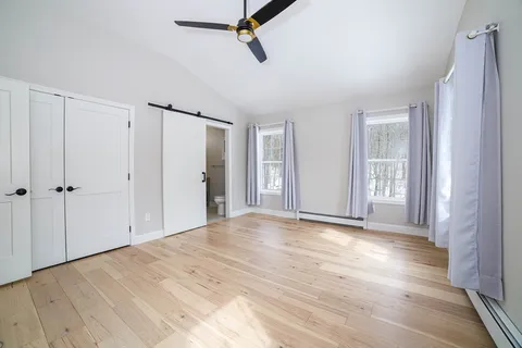 a view of an empty room with wooden floor