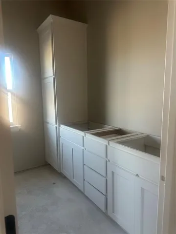 a view of cabinets and utility room with closet