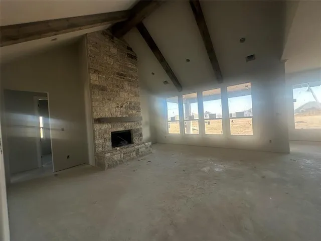 a view of an empty room with a fireplace and a window