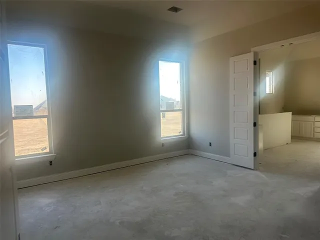 an empty room with windows and closet