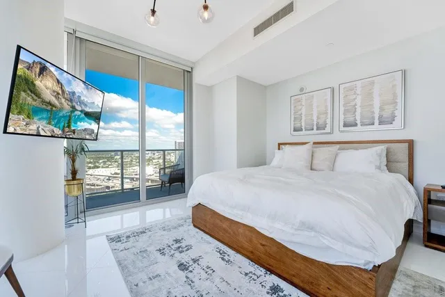 a bedroom with a large bed and a large window