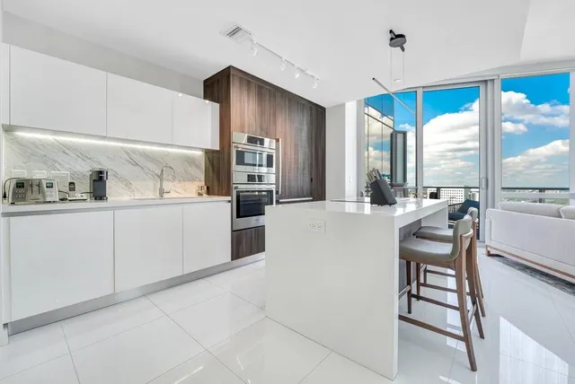 a kitchen with stainless steel appliances kitchen island granite countertop a sink and cabinets