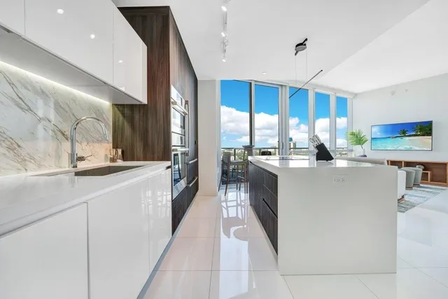 a kitchen with stainless steel appliances a sink stove and cabinets