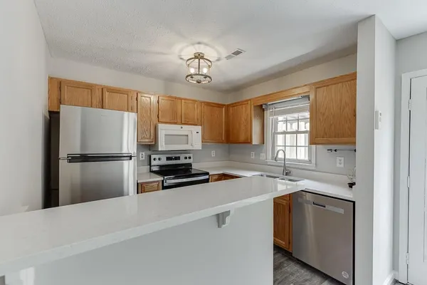 a kitchen with a refrigerator a sink cabinets and appliances