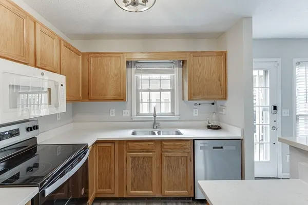 a kitchen with granite countertop a sink a stove and cabinets