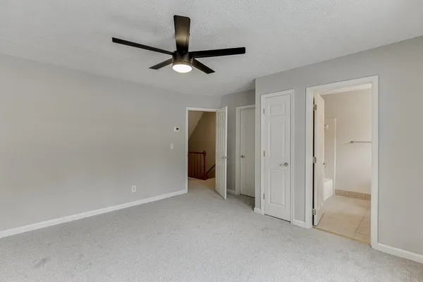 an empty room with a ceiling fan and a window