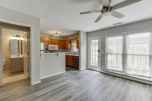 a view of a kitchen with stainless steel appliances wooden floor and a large window
