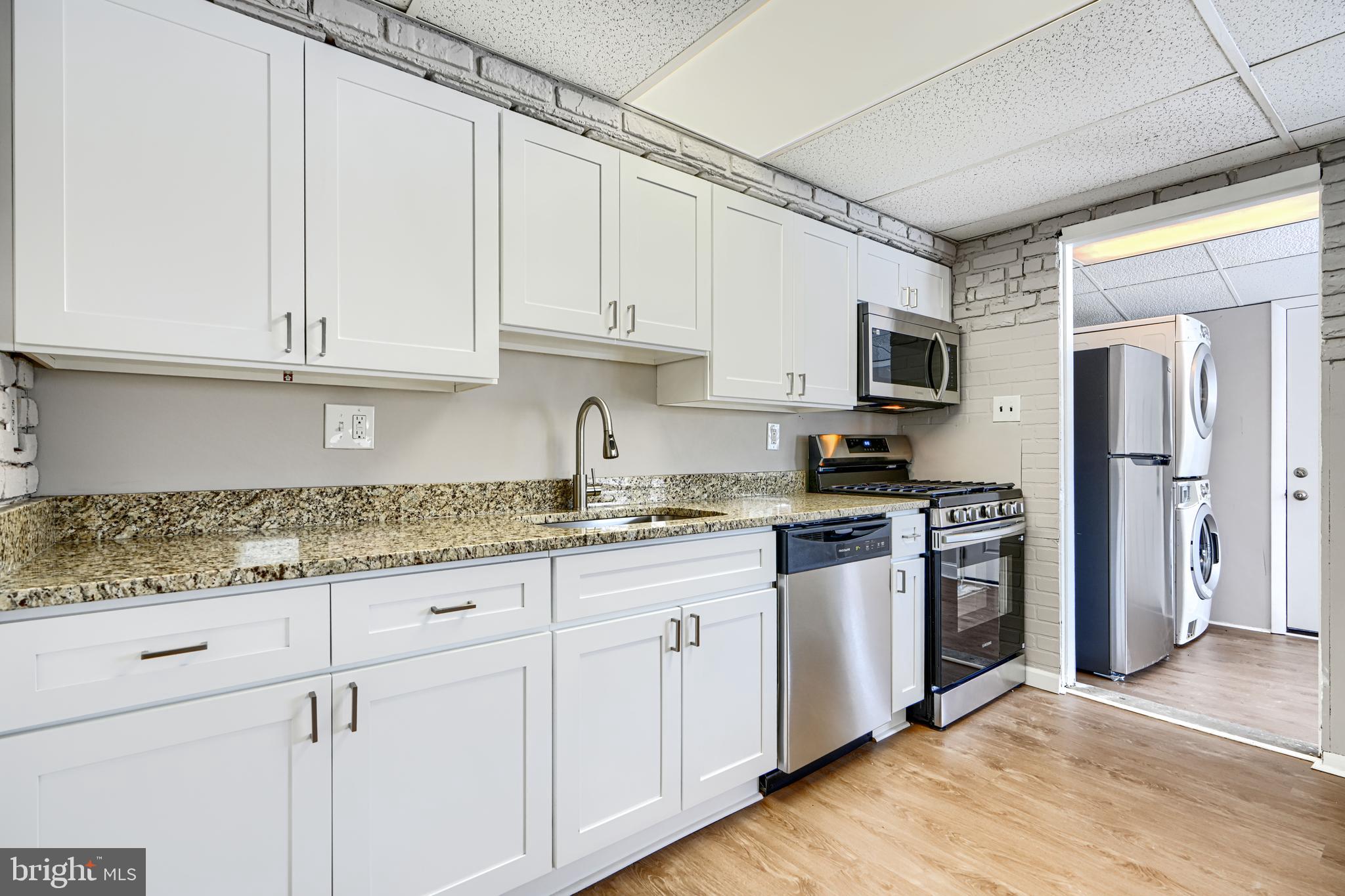 2014 Larkhall Road Dundalk, MD 21222 - Photo 17 of 44 a kitchen with granite countertop white cabinets and stainless steel appliances