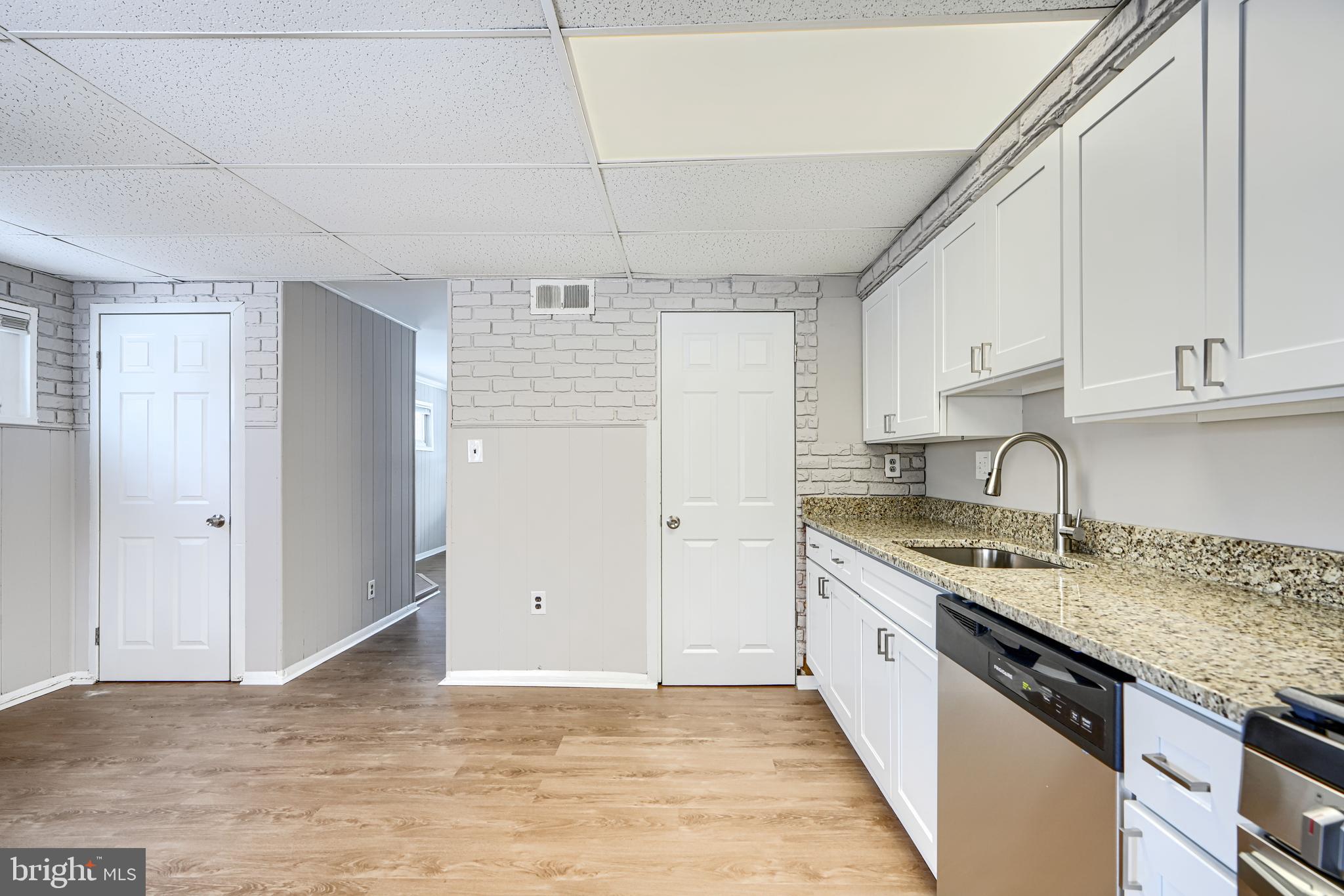 2014 Larkhall Road Dundalk, MD 21222 - Photo 18 of 44 a kitchen with granite countertop a sink stainless steel appliances white cabinets and a window