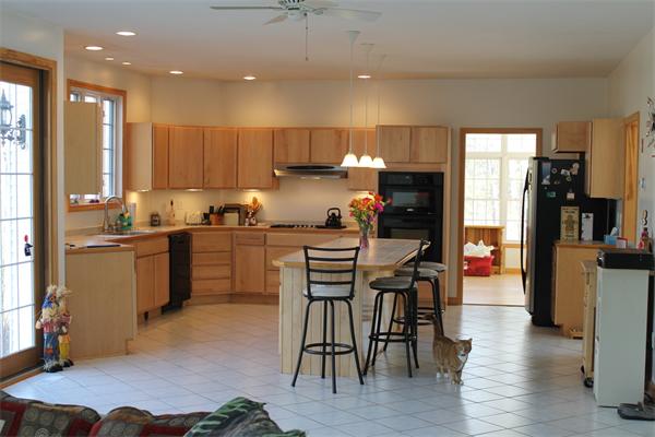 184 Rice Corner Road Brookfield, MA 01506 - Photo 8 of 15 a kitchen with a table chairs refrigerator and wooden cabinets