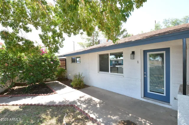 a backyard of a house with large trees and outdoor seating