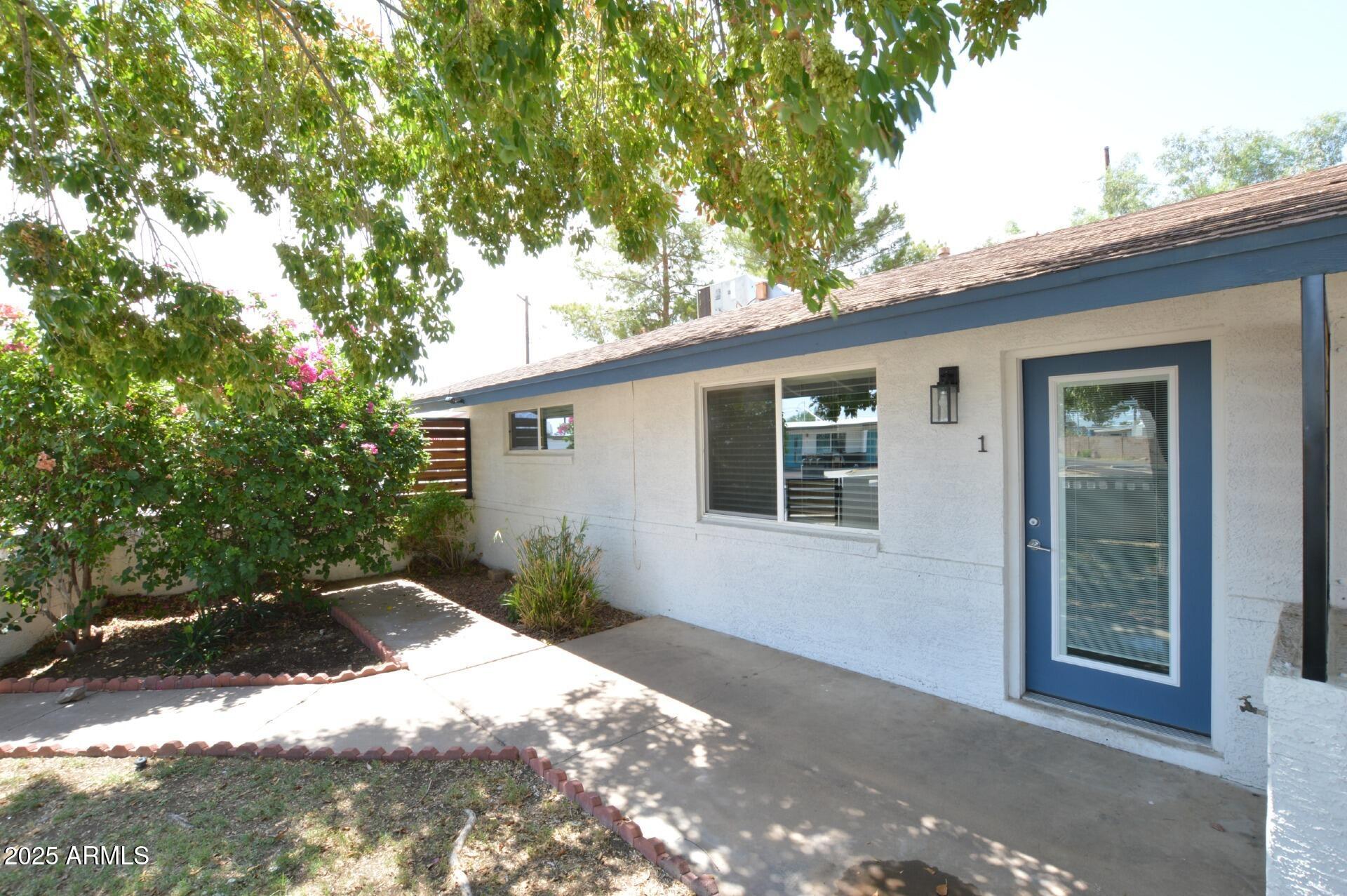 1202 East Kaler Drive, Unit 1 Phoenix, AZ 85020 - Photo 1 of 16 a backyard of a house with large trees and outdoor seating