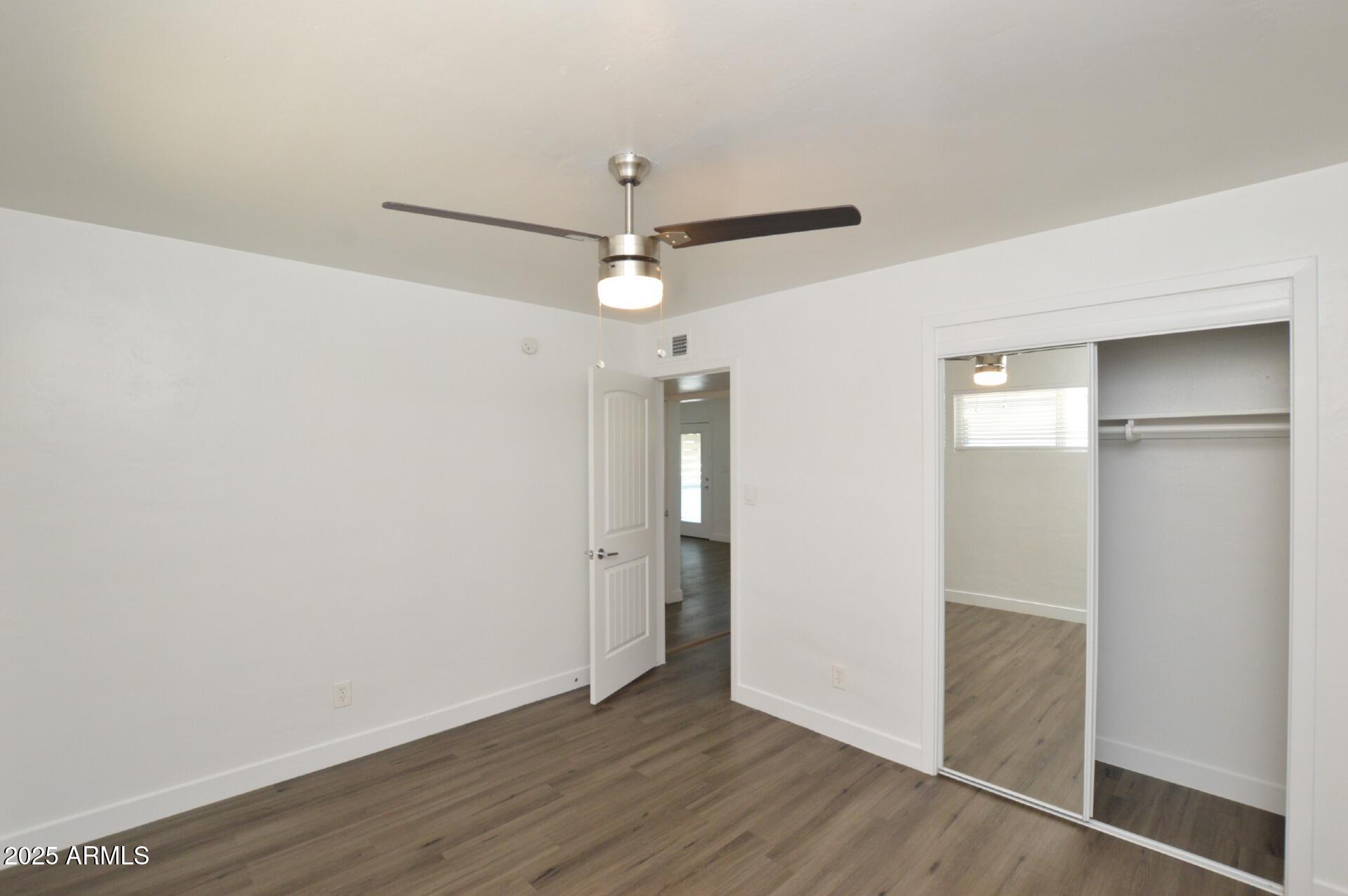 1202 East Kaler Drive, Unit 1 Phoenix, AZ 85020 - Photo 13 of 16 an empty room with wooden floor and a ceiling fan