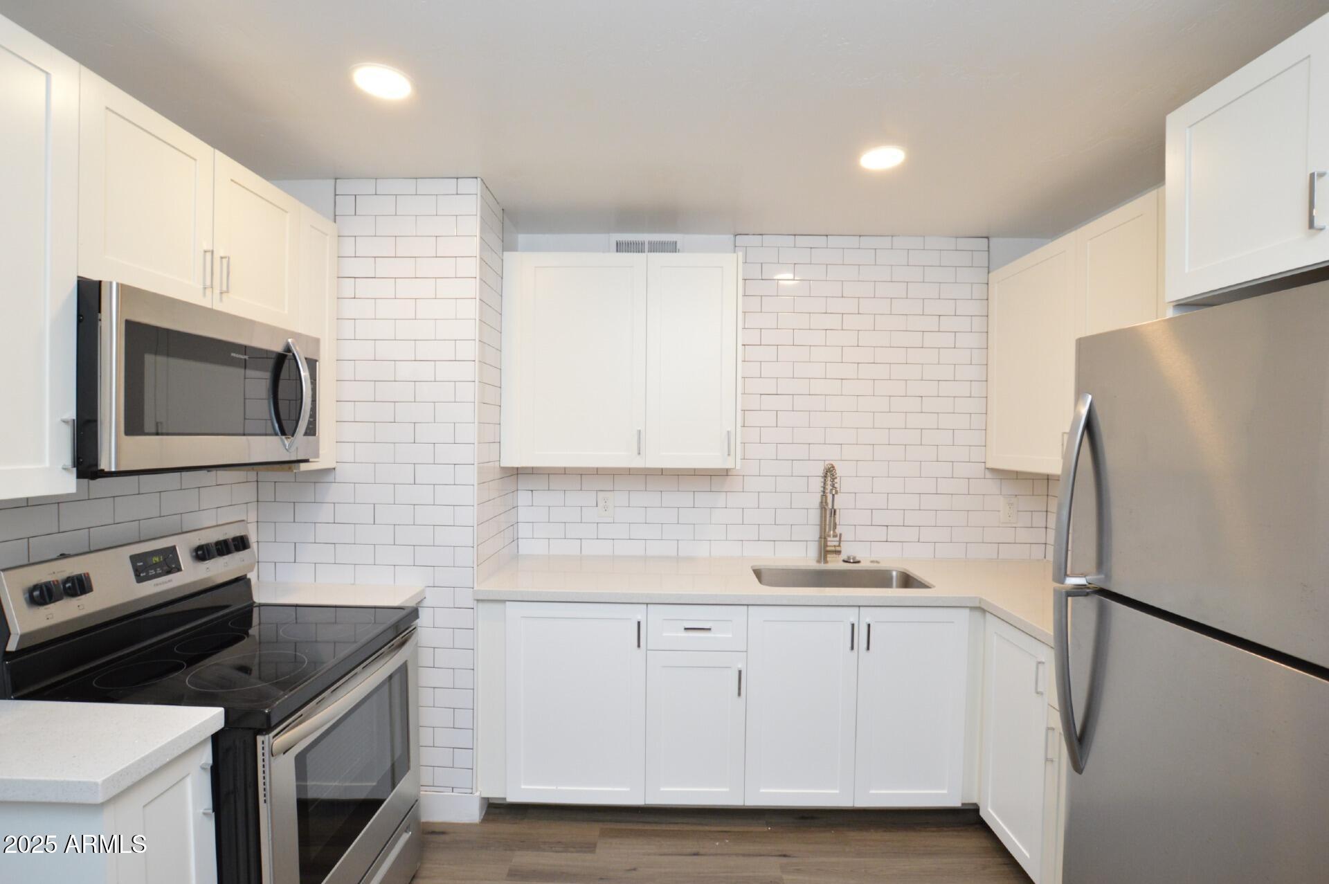 1202 East Kaler Drive, Unit 1 Phoenix, AZ 85020 - Photo 3 of 16 a kitchen with a refrigerator stove and sink