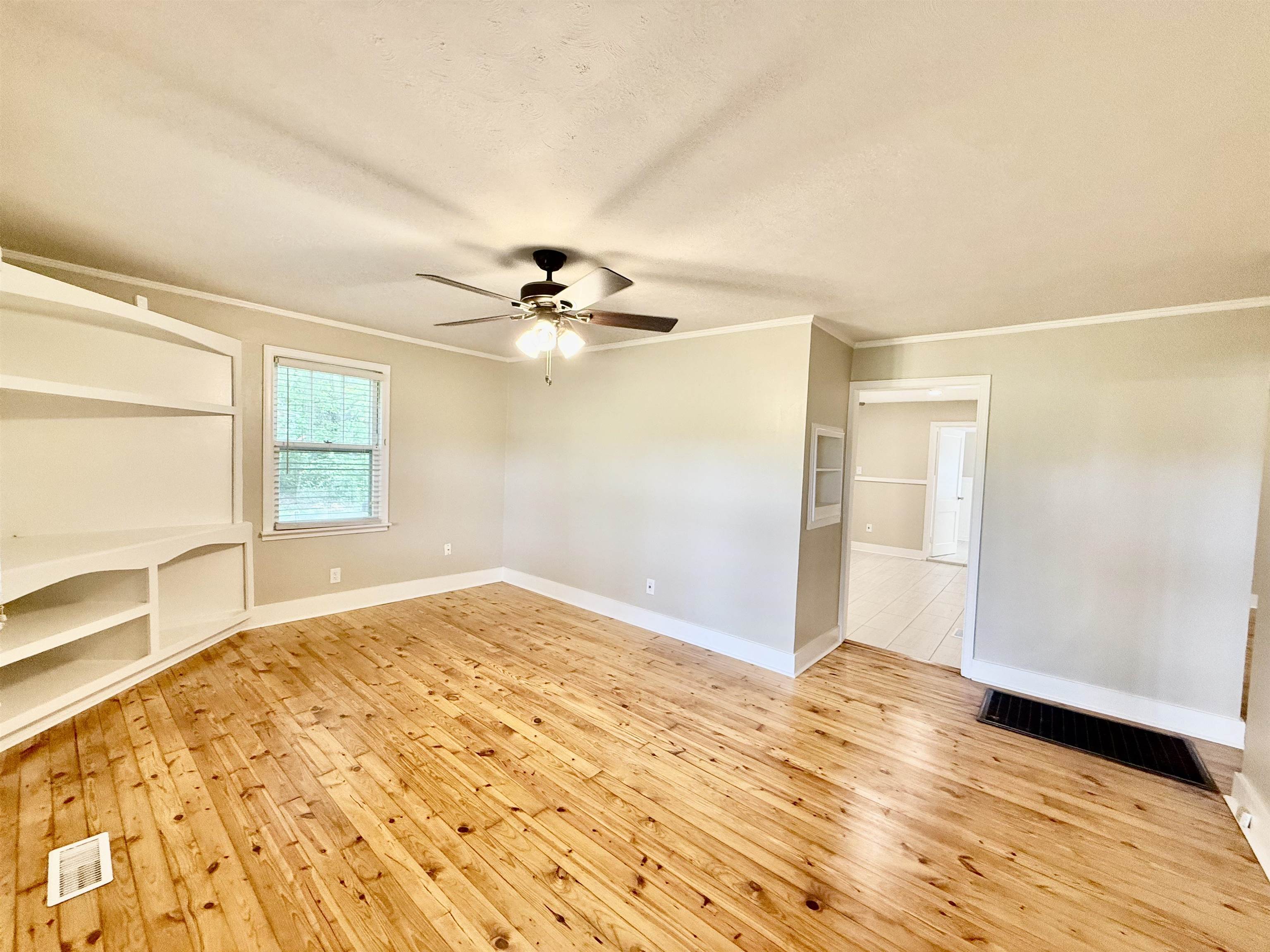 4120 Chambers Chapel Road Lakeland, TN 38002 - Photo 11 of 38 Unfurnished living room featuring ornamental molding, light wood-style flooring, ceiling fan, and baseboards