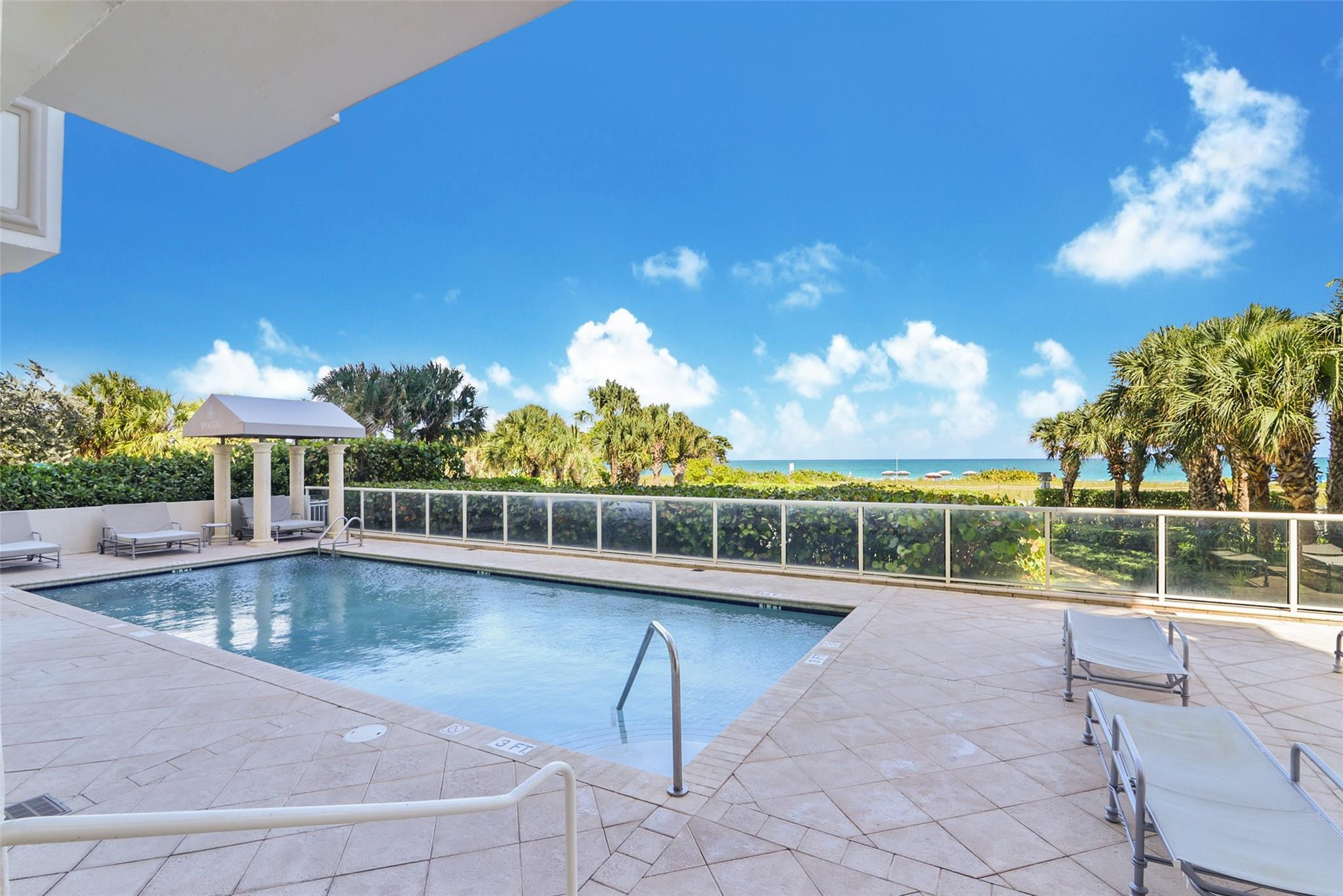 9499 Collins Avenue, Unit 603 Surfside, FL 33154 - Photo 41 of 42 Pool with shaded area and lounges