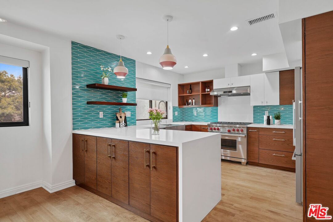 1569 Michael Lane Pacific Palisades, CA 90272 - Photo 17 of 31 a kitchen with a refrigerator a sink dishwasher with a dining table and chairs