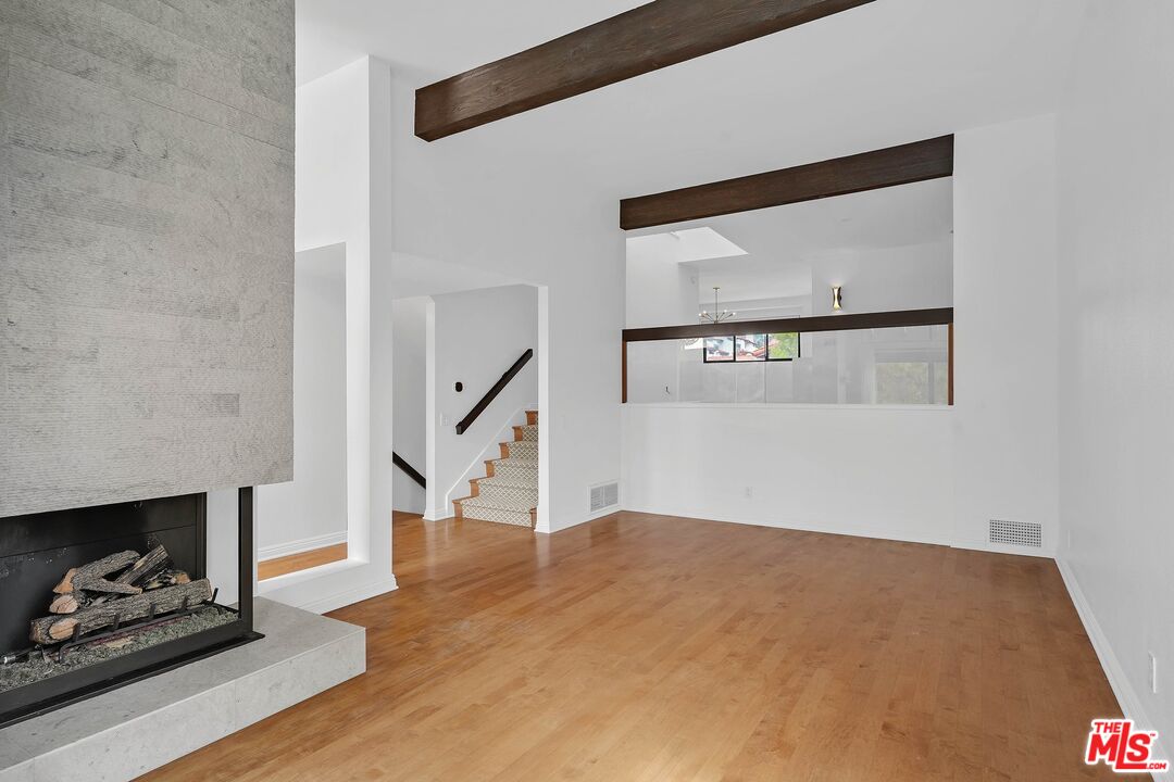 1569 Michael Lane Pacific Palisades, CA 90272 - Photo 6 of 31 a view of an empty room with wooden floor and a fireplace