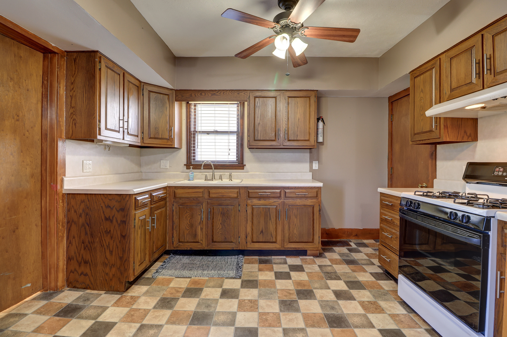 1305 3rd Avenue Sterling, IL 61081 - Photo 8 of 29 a kitchen with a stove a sink and a microwave