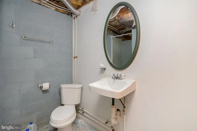 a bathroom with a toilet a sink and a mirror