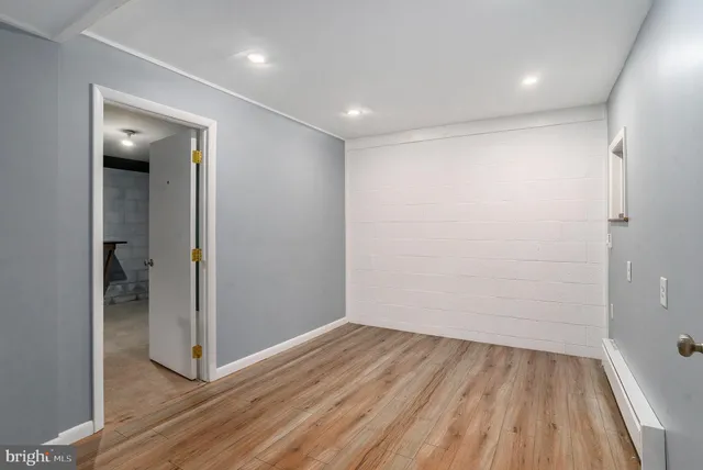 an empty room with wooden floor and entrance