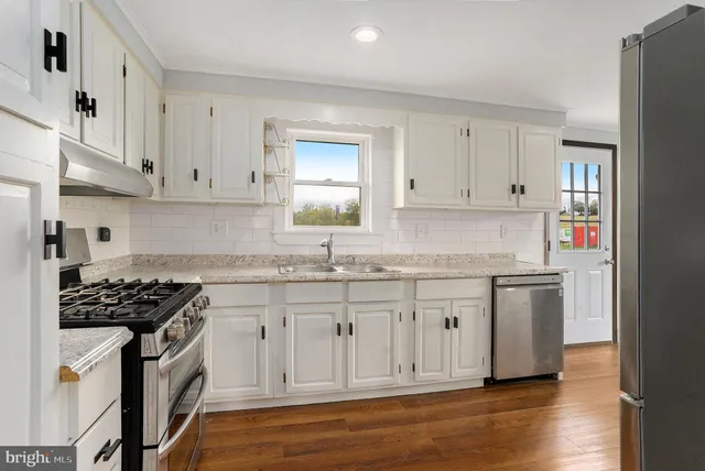 a kitchen with stainless steel appliances granite countertop a sink stove and cabinets