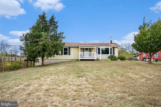 a view of a house with a yard and tree s