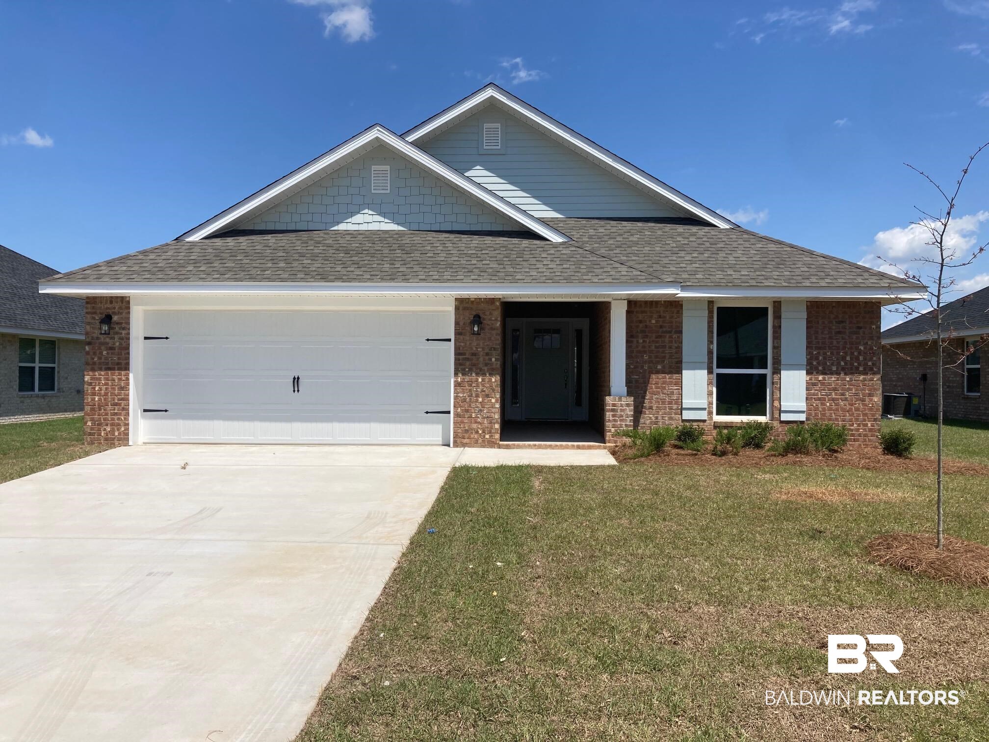 645 Revere Street Foley, AL 36535 - Photo 1 of 14 Craftsman-style home with a front yard, a garage, brick siding, driveway, and roof with shingles