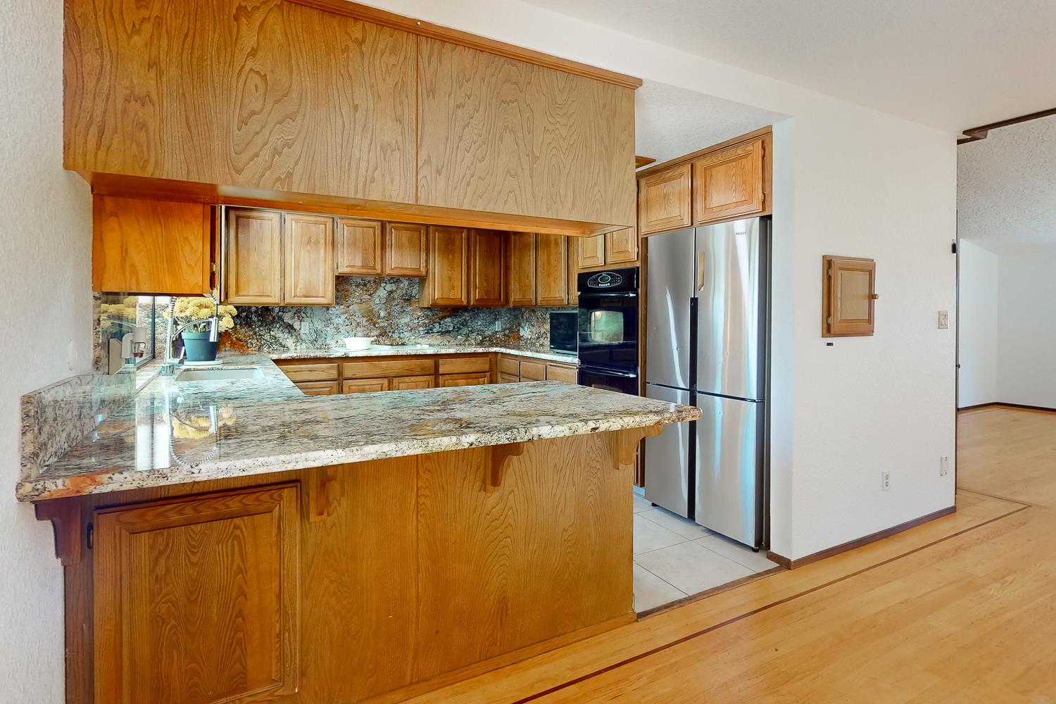 22801 Hidden Ranch Road Auburn, CA 95602 - Photo 6 of 94 a kitchen with stainless steel appliances granite countertop a refrigerator a stove and a sink with wooden floor