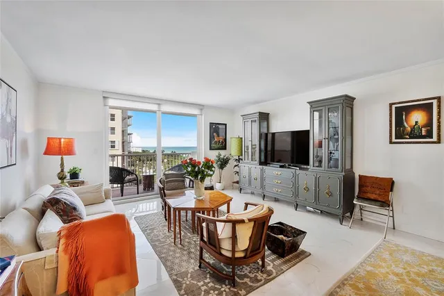 a living room with furniture a flat screen tv and kitchen view