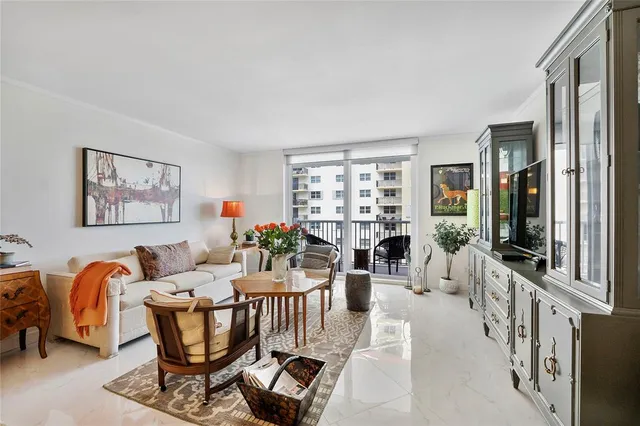 a living room with furniture a couch and a bookshelf next to a window