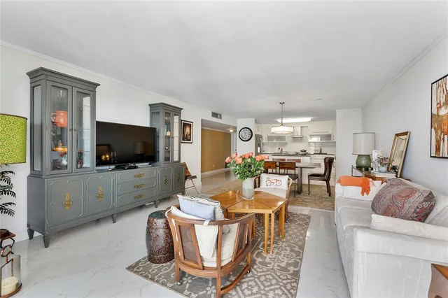a living room with furniture a flat screen tv and kitchen view