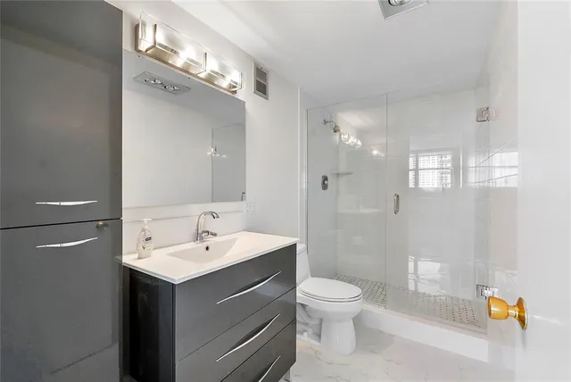 a bathroom with a sink a toilet and shower